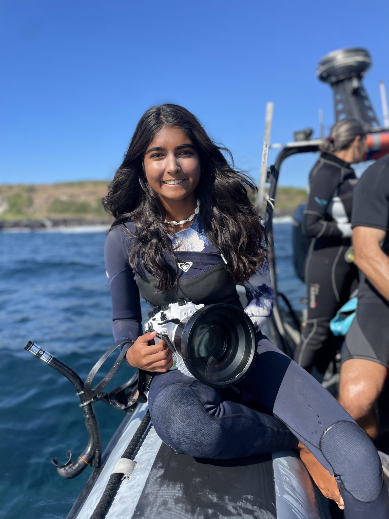 A young Green Heroes volunteer with an underwater camera on the boat at Cook Island